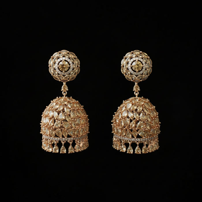 Pair of gold earrings with intricate designs on a black stand.