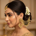 Gold necklace and earrings set with 'SAHELI' branding on a dark background