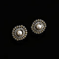 Pair of gold and pearl earrings on a dark background with 'Saheli' branding.