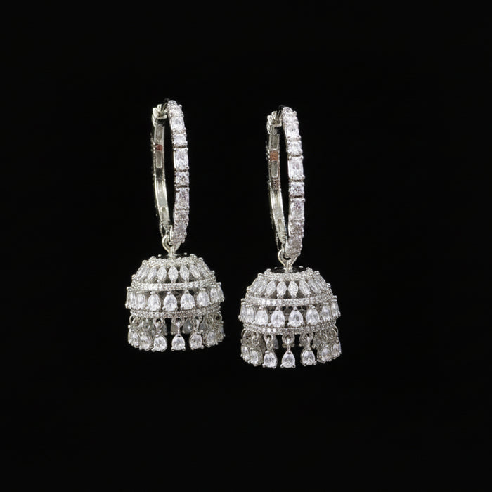 Jewelry store setting with a hand holding a pair of earrings.