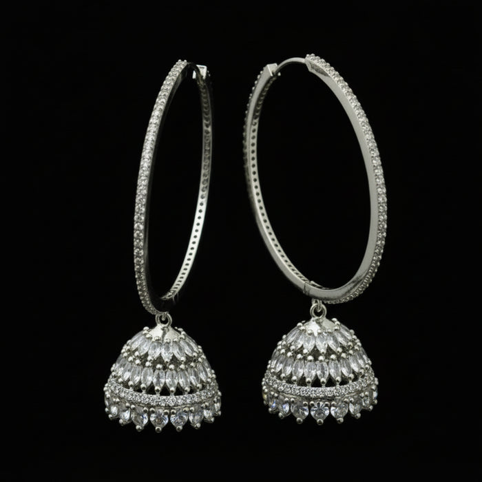 Silver hoop earrings on a black stand with 'Saheli' branding.