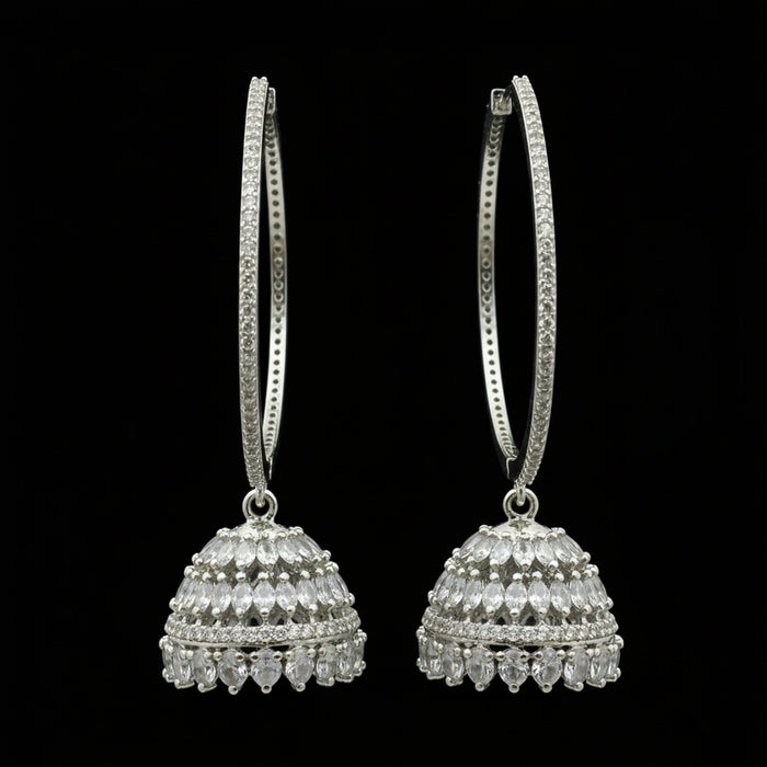 Silver hoop earrings on a black stand with 'Saheli' branding.