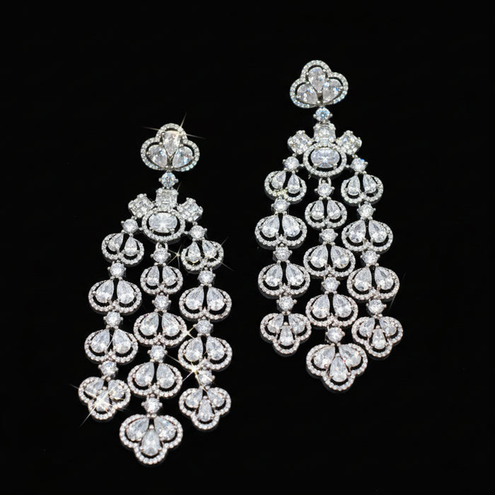 Pair of diamond chandelier earrings on a dark background