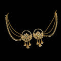Gold necklace with intricate designs on a gray background, featuring the brand 'Saheli'.