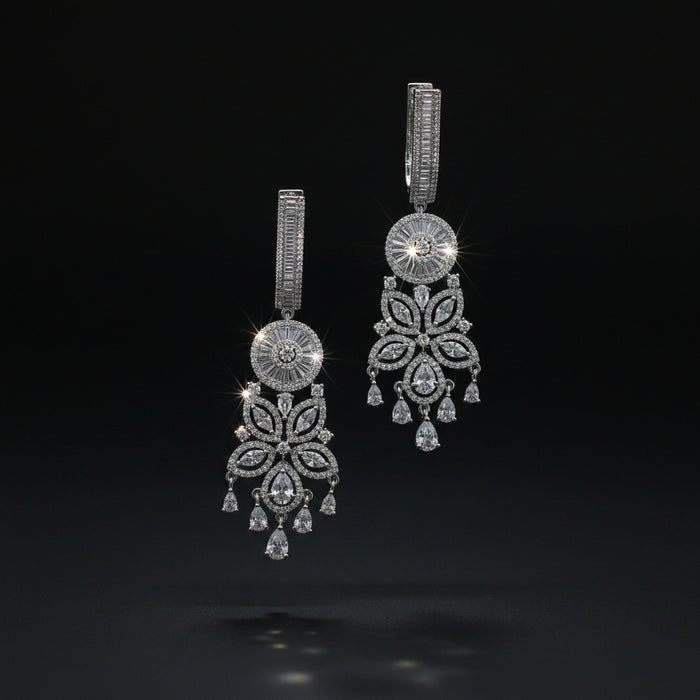 Pair of silver chandelier earrings on a dark background