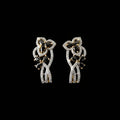 Pair of diamond earrings on a dark gray stand with 'Saheli' branding.