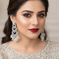 Pair of silver and pearl earrings on a dark background