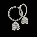 Silver earrings held by a hand with a blurred background
