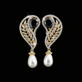 A pair of gold and crystal drop earrings with white pearl teardrops, displayed on a black stand against a dark gray background. The brand logo 'SAHELI MY BEST FRIEND' is visible in the top left corner.