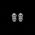 Silver earrings on a black stand with 'Saheli' branding on a dark background