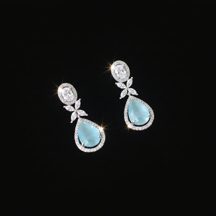 Pair of earrings with turquoise stones on a dark background
