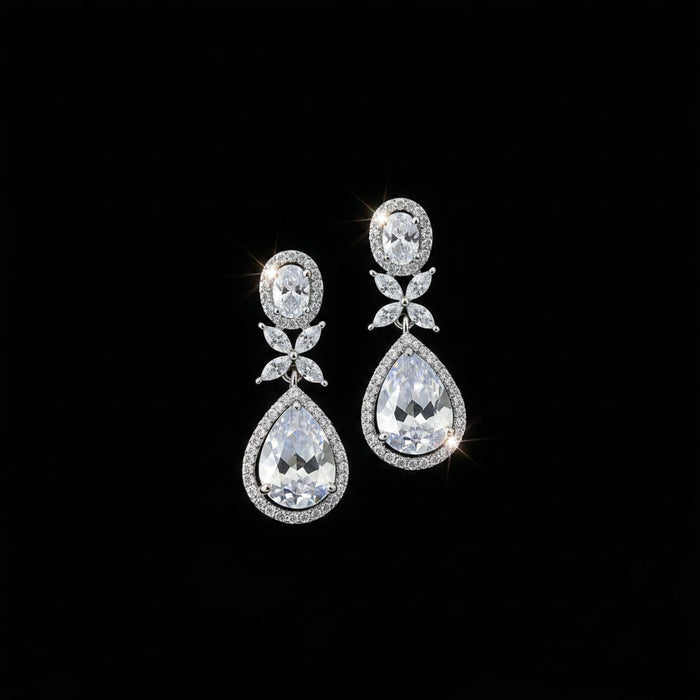 Pair of teardrop-shaped earrings with clear stones on a dark background