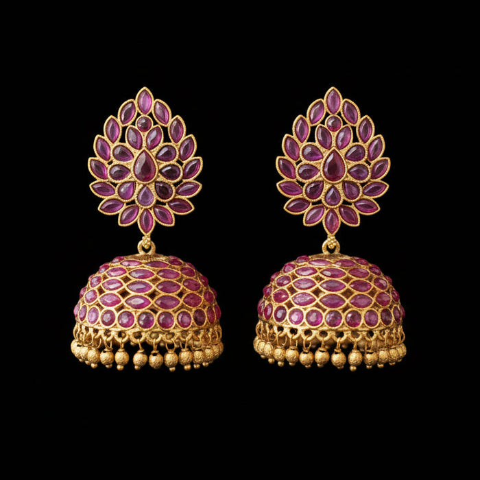 Gold and pink gemstone earrings on a gray stand