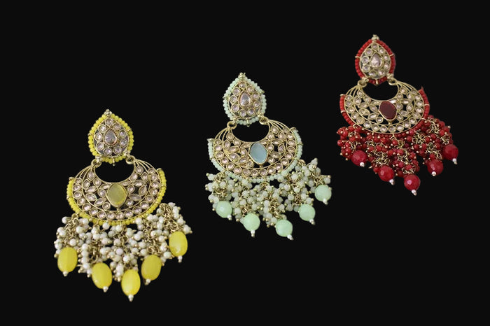 Three pairs of ornate earrings with different color schemes on a gray background, branded 'Saheli'.