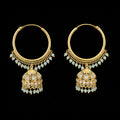 Gold hoop earrings with green gemstones on a black background