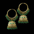 Gold and green beaded earrings on a black stand with 'Saheli' branding.