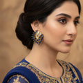 Pair of gold and blue earrings on a dark background with 'SAHELI' branding.