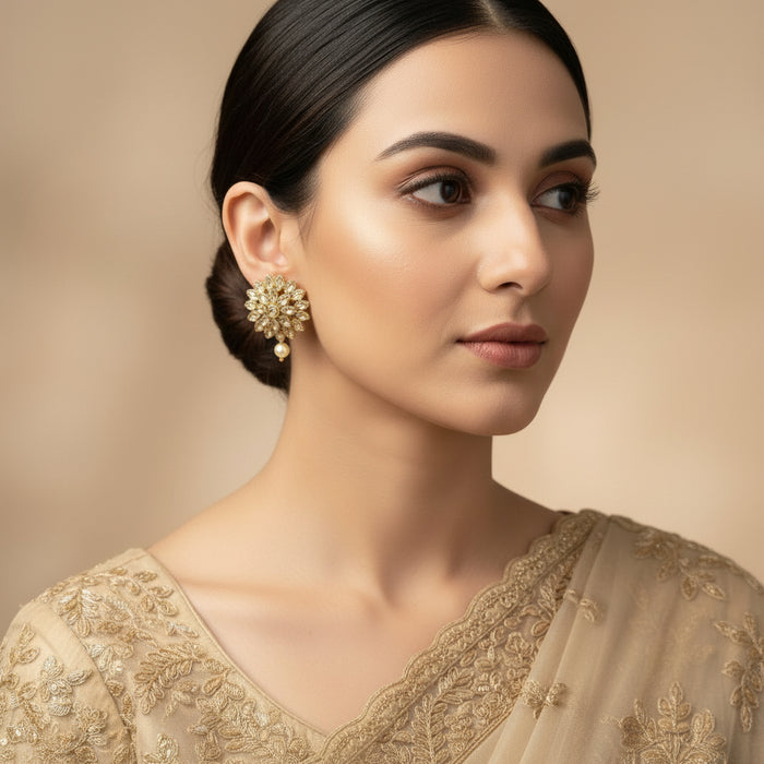 Pair of gold and pearl earrings on a dark gray background