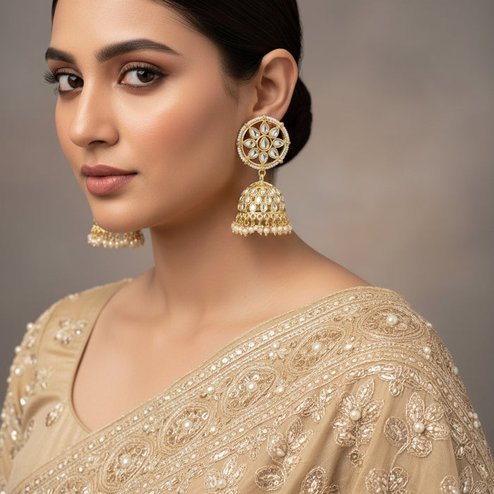 Gold and pearl earrings on a gray stand with 'SAHELL' branding.
