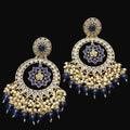Pair of gold and blue earrings on a dark gray background