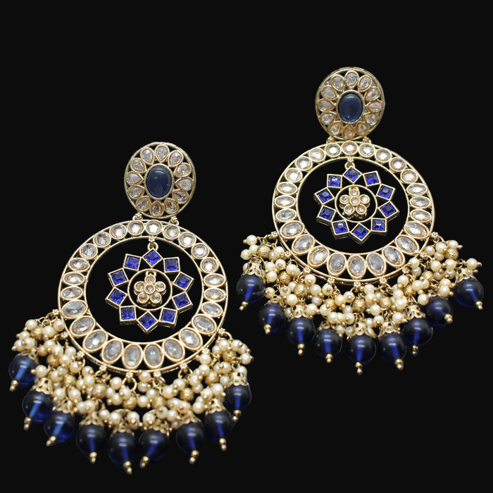Pair of gold and blue earrings on a dark gray background