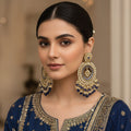 Pair of ornate earrings with blue and gold details on a gray background