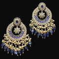 Ornate gold and blue earrings on a dark gray background