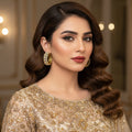 Gold hoop earrings with diamonds on a dark background, featuring the brand 'Saheli'.