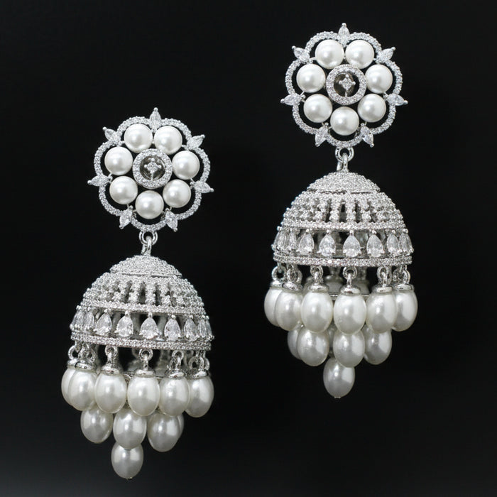 Pair of silver and pearl earrings on a black background