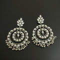 Pair of silver earrings with intricate designs on a black background