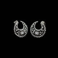 A pair of silver-toned crescent-shaped earrings adorned with numerous clear stones, featuring a central square-cut stone, displayed on a dark gray background.