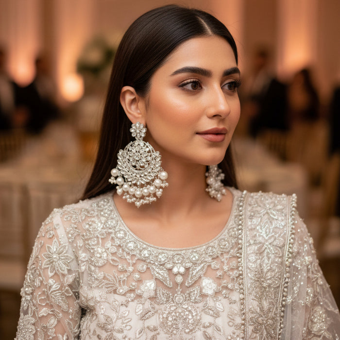 Pair of silver and pearl earrings on a dark background