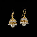 Gold and pearl earrings on a black display stand