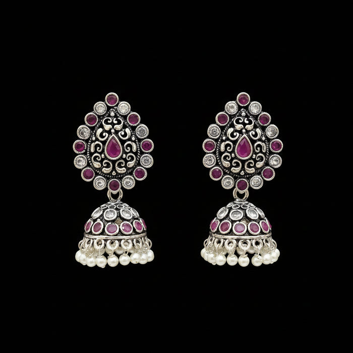 Pair of silver and pink earrings on a gray stand with 'Saheli' branding.