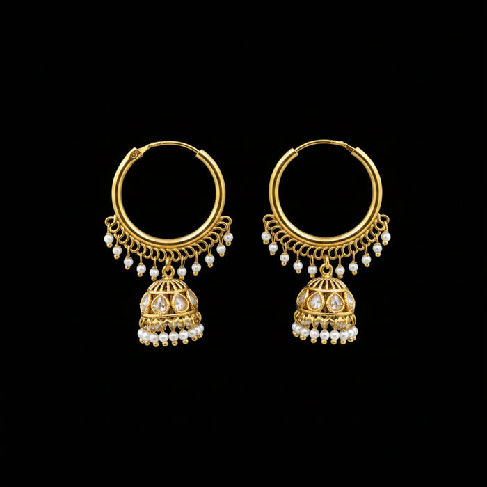 Gold earrings with pearl drops on a gray stand, branded 'Saheli'.