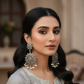Pair of silver floral earrings on a black stand