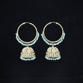 Pair of gold hoop earrings with turquoise stones on a black background