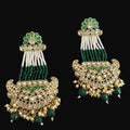 Pair of ornate earrings with green and gold details on a dark background
