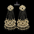 Ornate gold earrings with black stones on a black background, featuring the brand 'Saheli'.
