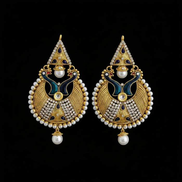 A pair of ornate gold-toned traditional Indian earrings with white faux pearls, dark blue enamel, and silver-toned stone accents, displayed on a dark reflective surface with the brand name SAHELL MY BEST FRIEND at the top.