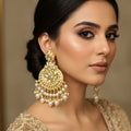 Pair of gold and pearl earrings on a black background