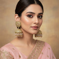 Gold and pearl earrings on a gray background with HP logo.