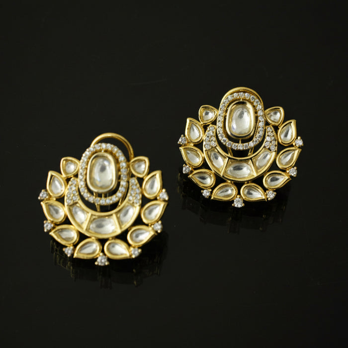 Pair of gold and diamond earrings on a black background