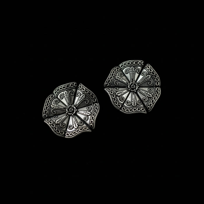 Pair of silver decorative earrings on a dark gray background