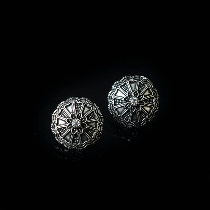 Pair of silver floral earrings on a dark gray background