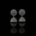 Silver earrings on a peacock feather with a dark background