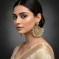 Pair of gold earrings with gemstones on a black background
