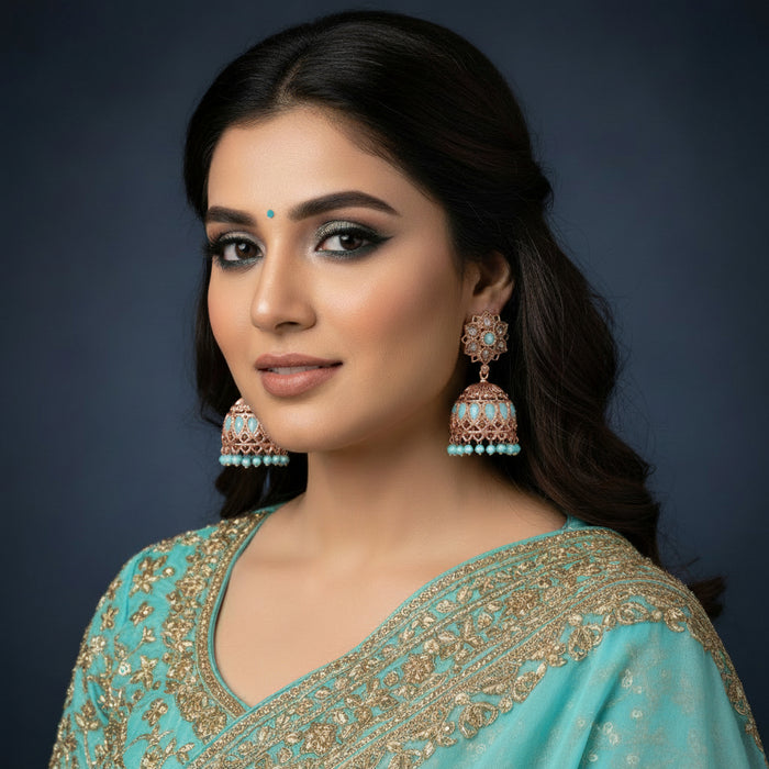 Gold and turquoise earrings on a black stand with a black background