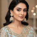 Pair of ornate earrings with blue stones on a black background