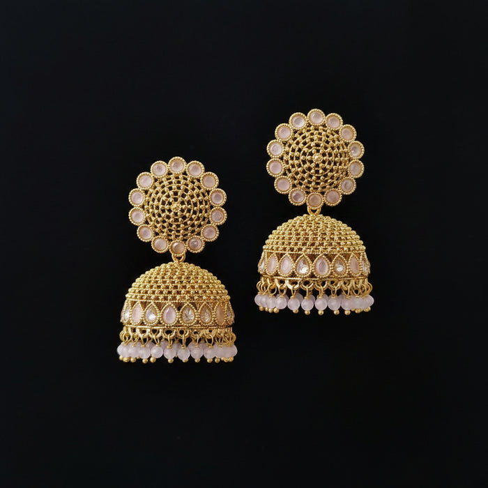 Gold earrings with intricate design on a dark background